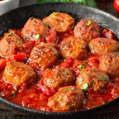 Pyszne mielone w sosie pomidorowym, podane w czarnej patelni. Aromatyczne, soczyste klopsiki w bogatym sosie.
