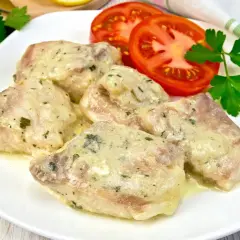Porcja miruny w sosie śmietanowym z pomidorami i natką pietruszki. Czy to ryba, którą chcesz dziś przyrządzić?