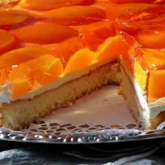 Sernik z brzoskwiniami w galaretce, idealny deser, który pokazuje, ile tężeje galaretka.