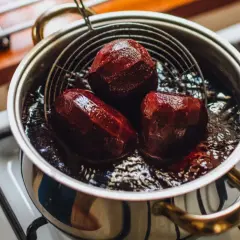 Gotowanie buraków na kuchence. Trzy buraki w garnku z wodą, gotowe do dalszego wykorzystania.