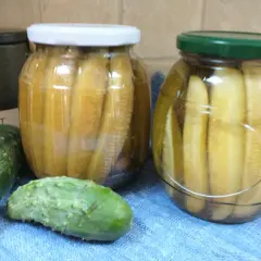 Słoiki z ogórkami po watykańsku, obok świeże ogórki i pojemnik z napisem "SALT".