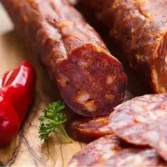 Chorizo co to? Pikantna kiełbasa, czerwona papryka i natka pietruszki na desce.
