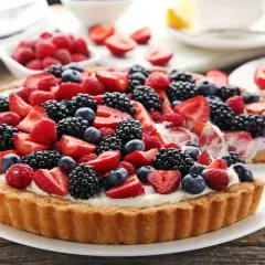 Pyszna tarta z mascarpone, udekorowana świeżymi malinami, borówkami i jeżynami. Idealna na letnie popołudnie.