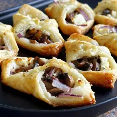 Pyszne przekąski z ciasta francuskiego z pieczarkami, serem i czerwoną cebulą. Idealne na imprezę!