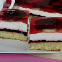 Pyszne ciasto z delicjami, warstwami kremu i galaretki z owocami. Idealne na deser.