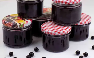 Słoiczki pełne domowego dżemu z czarnej porzeczki, gotowe na zimowe wieczory.