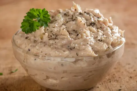 Kremowa pasta z tuńczyka i jajka, doprawiona pieprzem, udekorowana natką pietruszki. Idealna na kanapki.