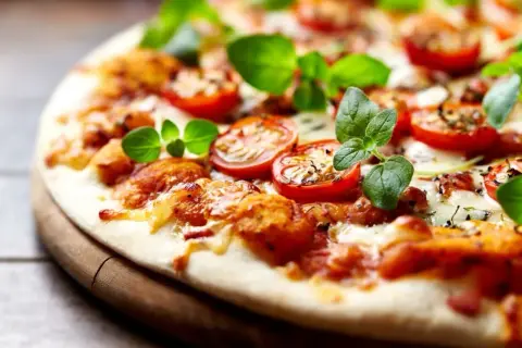 Pyszna pizza bez drożdży z pomidorkami i świeżą bazylią, idealna na szybki obiad.
