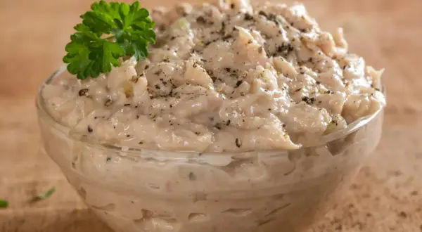 Kremowa pasta z tuńczyka i jajka, doprawiona pieprzem, udekorowana natką pietruszki. Idealna na kanapki.