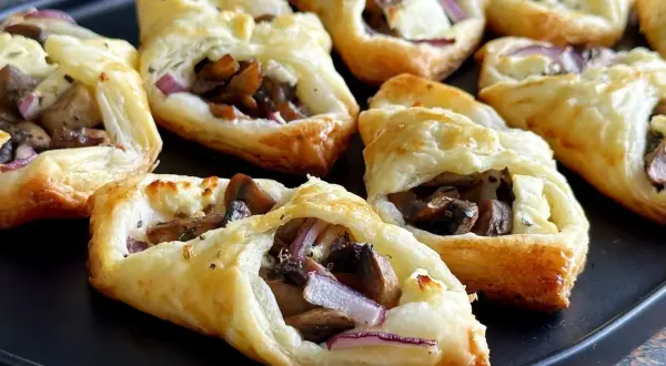 Pyszne przekąski z ciasta francuskiego z pieczarkami, serem i czerwoną cebulą. Idealne na imprezę!