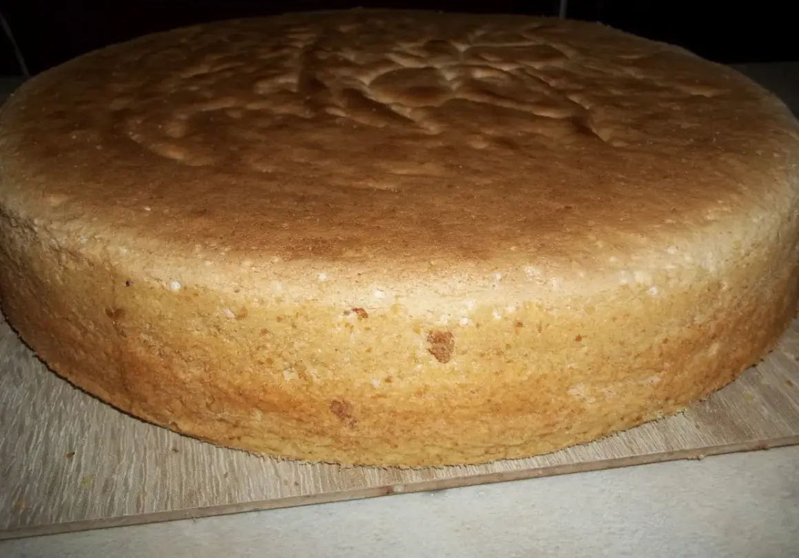 Puszysty biszkopt z 5 jaj, lekko zarumieniony, gotowy do dekoracji. Idealna baza do tortu.