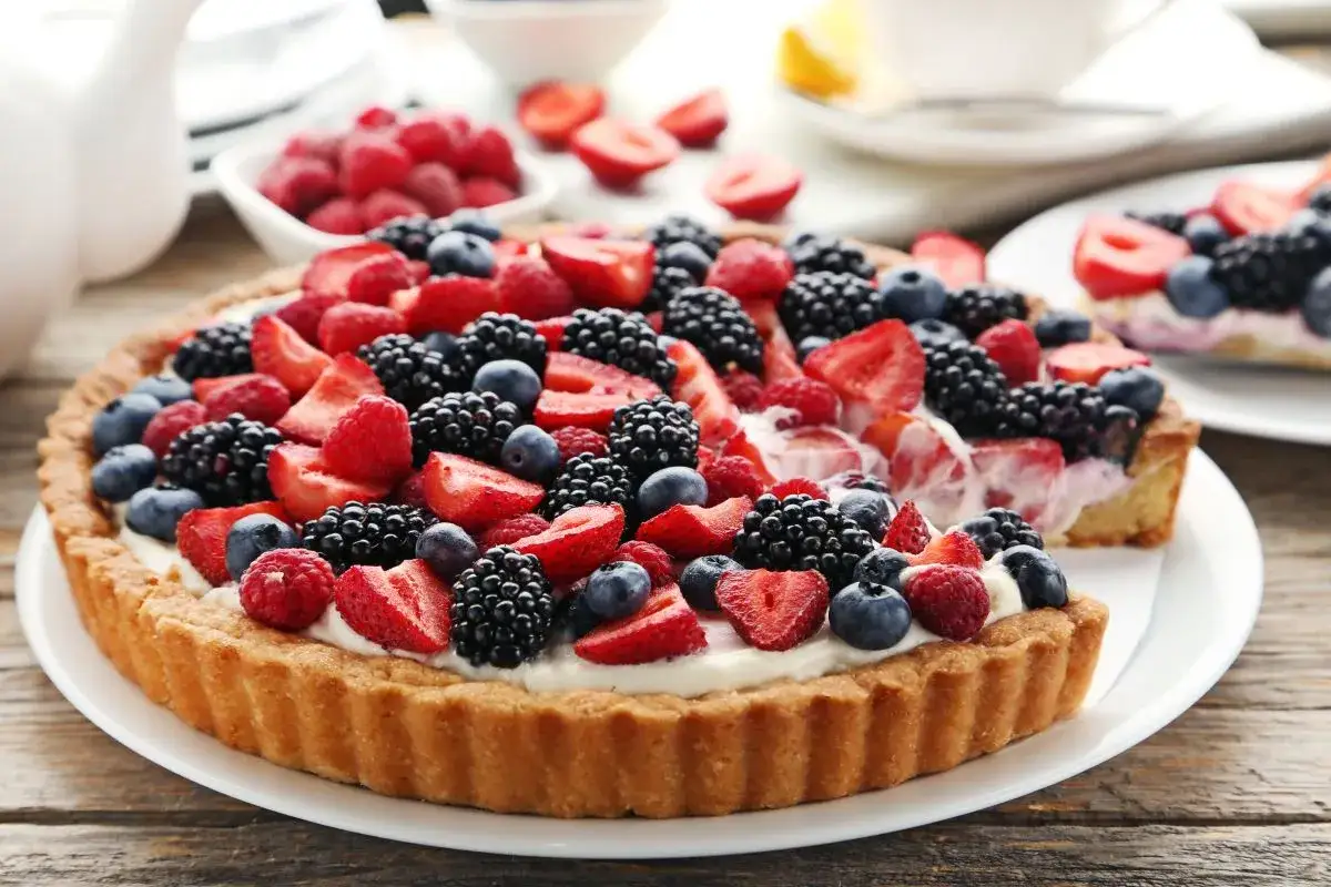 Pyszna tarta z mascarpone, obficie udekorowana świeżymi malinami, bor&oacute;wkami i jeżynami. Idealna na letnie popołudnie.