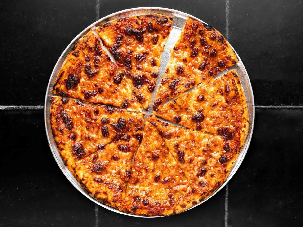 Chrupiąca pizza bez drożdży, obficie posypana serem, pokrojona na 8 kawałk&oacute;w. Idealna na szybki obiad.