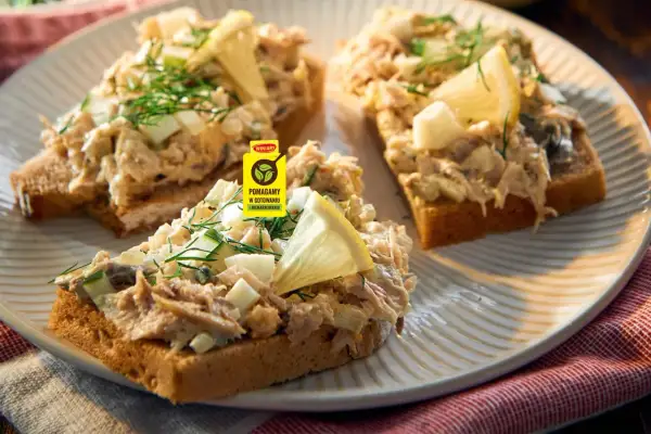 Pyszna pasta z makreli z jajkiem i ogórkiem na tostach, udekorowana cytryną i koperkiem. Idealna na szybkie śniadanie.