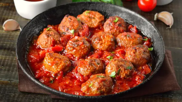 Pyszne mielone w sosie pomidorowym, podane w czarnej patelni. Aromatyczne, soczyste klopsiki w bogatym sosie.