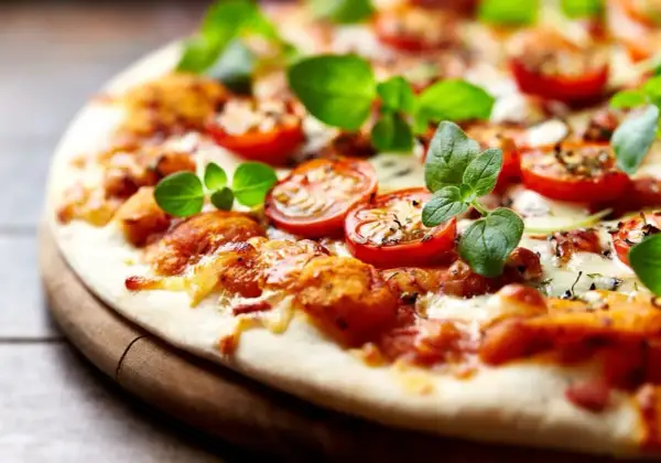 Pyszna pizza bez drożdży z pomidorkami i świeżą bazylią, idealna na szybki obiad.